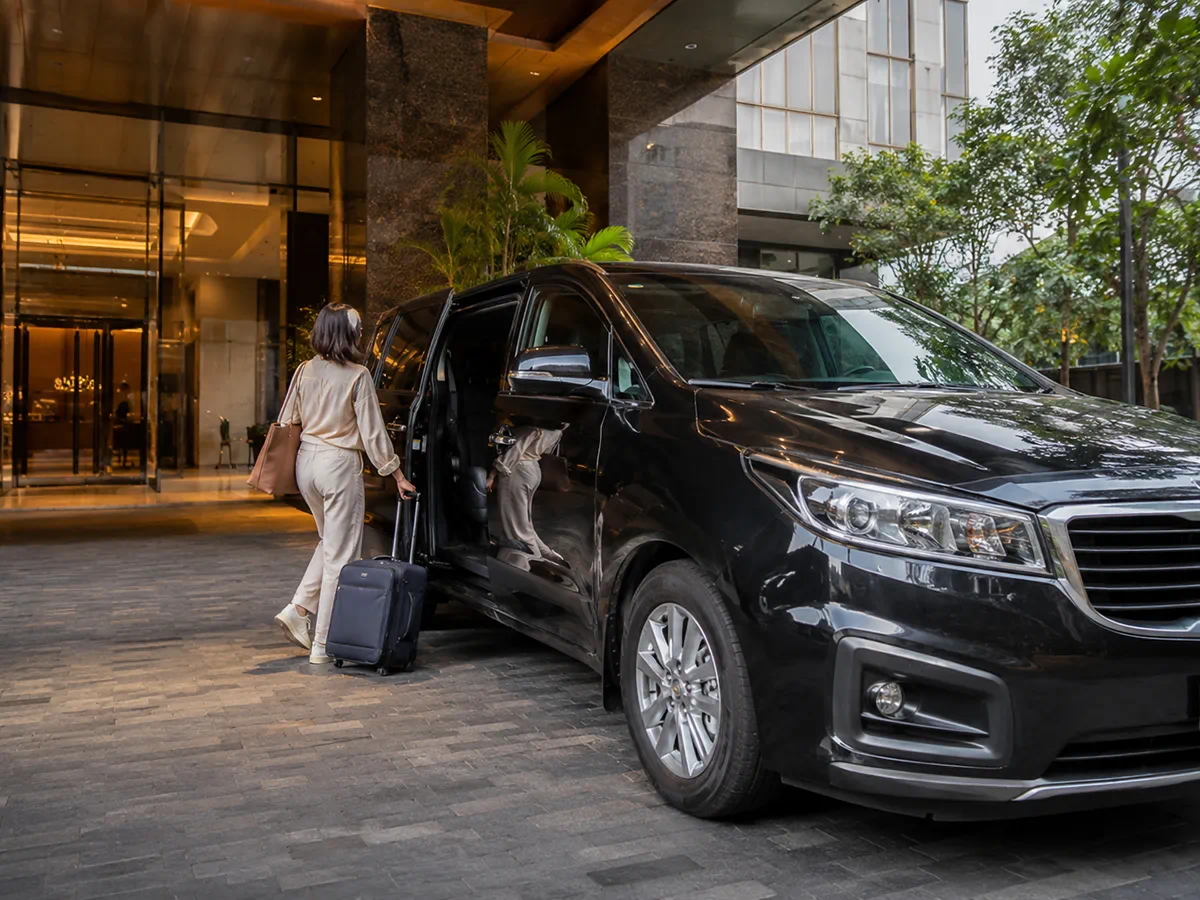 Traveler boarding a private car at a hotel entrance